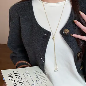 Elegant gold-plated sweater chain detail featuring a zircon knot and twin pearl drops