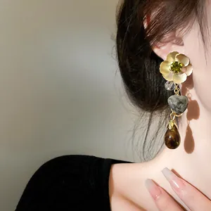 Detailed close-up of vintage ethnic style floral heart and teardrop dangle earrings