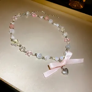 Sweet heart star beaded necklace featuring a pink ribbon bow and cat eye stones.