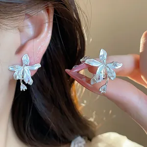 Detailed view of exquisite silver-tone zircon flower stud earrings on ear
