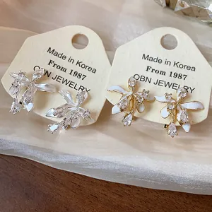 Close-up detail of 18k gold plated flower stud earrings with sparkling zircon stones