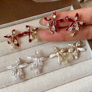 Detailed macro view of 18k gold plated zircon flower stud earrings on jewelry tray
