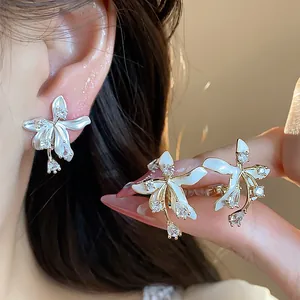 Close-up shot of elegant flower stud earrings with zircon stones and 18k gold plating