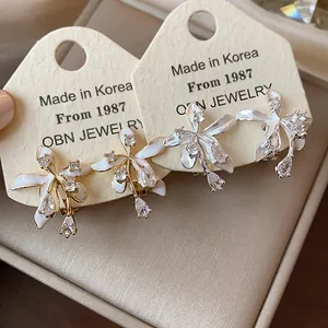 Close-up detail of delicate flower stud earrings with shimmering zircon stone petals