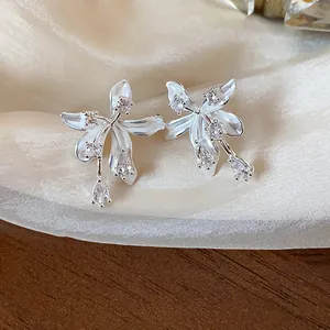 Close-up view of elegant silver flower stud earrings adorned with shimmering zircon stones