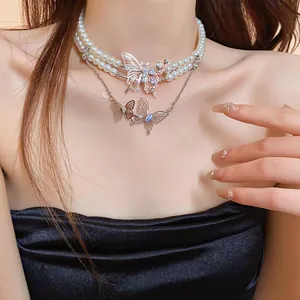 Close-up detail showing the layered butterfly pearl necklace with sparkling rhinestones