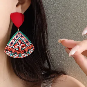 Detailed close-up showing bohemian style triangular acrylic earrings worn by a model