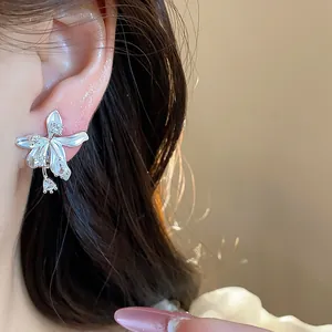 Detailed macro view of 18k gold plated flower stud earrings with zircon on model