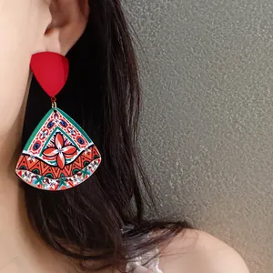 Close-up detail of retro ethnic acrylic printed triangle earrings worn by a model
