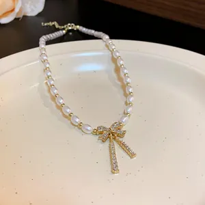 Detailed view of elegant pearl necklace with a sparkling rhinestone bow pendant charm