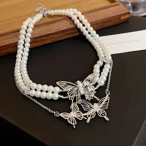 Exquisite detail view of double-strand pearl necklace with rhinestone butterfly charms