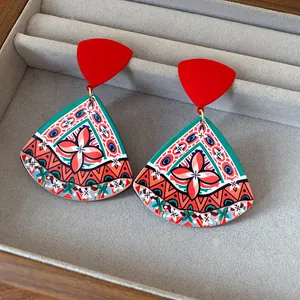 Detailed macro view of vintage ethnic style acrylic triangle drop earrings with red studs