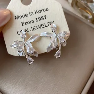 Detail view of the 18k gold plated flower stud earrings with shimmering zircon stones