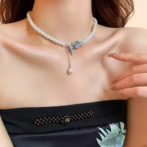 Elegant faux pearl choker necklace featuring a blue crystal butterfly pendant and tassel