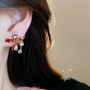 Detailed close-up of 18k gold-plated zircon flower stud earring worn on model ear