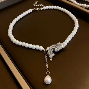 Detailed shot of a French style necklace with white pearls and a crystal butterfly pendant