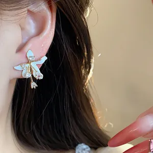 Close-up detail of exquisite white enamel flower stud earrings with sparkling zircon stones