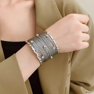 Vista dettagliata di un bracciale a polsino argento multistrato con strass sul polso
