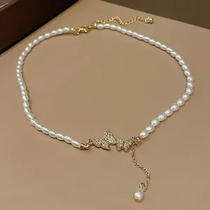 Detailed view of elegant pearl necklace featuring a sparkling rhinestone butterfly pendant.