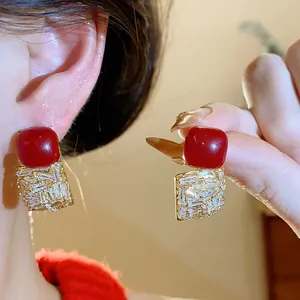 Détail de boucles d'oreilles carrées rouges vintage avec zircons étincelants