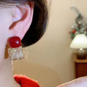 Gros plan détaillé de boucles d'oreilles vintage rouges et zircones sur l'oreille