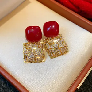 Détail de boucles d'oreilles carrées vintage avec pierres rouges et zircons clairs