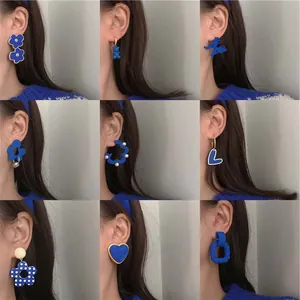 Collection of trendy Klein blue earrings in floral, heart, and bear shapes with silver needles