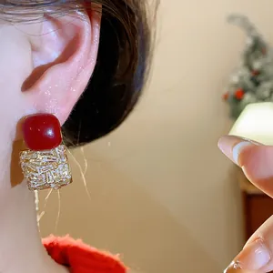 Gros plan détaillé de boucles d'oreilles vintage avec zircon cubique carré et pierre rouge
