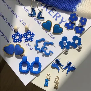 Collection of trendy Klein blue earrings in various shapes like hearts and floral designs