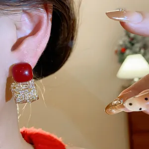 Vue détaillée de boucles d'oreilles vintage carrées avec pierre rouge et détails en zircone pavé