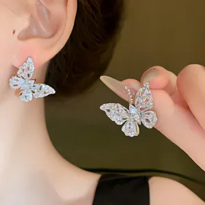 Dettaglio ravvicinato di orecchini a farfalla in zircone scintillante in argento