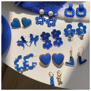 Assortment of stylish Klein blue earrings with heart, flower, and butterfly motifs