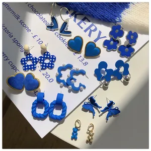 A diverse collection of Klein blue fashion earrings featuring heart and butterfly shapes