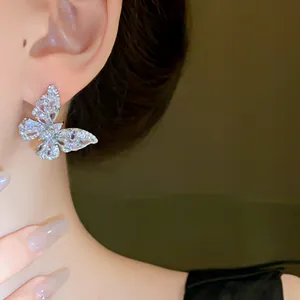 Macro di eleganti orecchini a perno a farfalla in zirconia su un modello