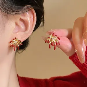Close-up of 18k gold plated firework stud earrings with red petals and zircon centers.