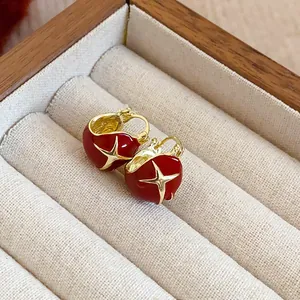 Exquisite Ankora red heart flower earrings with gold star accents inside a jewelry box
