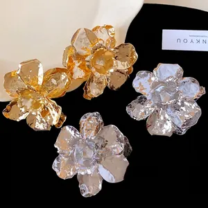 Elegant crumpled metal flower stud earrings available in gold and silver finishes