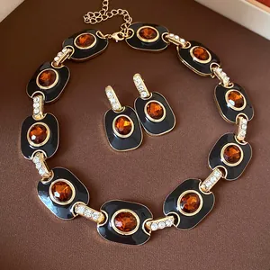 Detailansicht von Vintage-Halskette und Ohrringen mit schwarzem Emaille und Bernsteinsteinen.