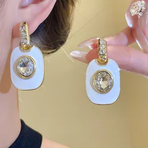 Detailansicht der Vintage-Ohrringe mit weißem Emaille und großem klarem Edelstein