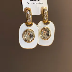 Makroansicht von Vintage-Emaille-Ohrringen mit großen ovalen Kristallsteinen