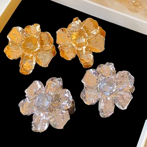 Macro view showing the metallic crumpled texture of gold and silver flower earrings