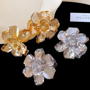 Macro view of exquisite metallic crumpled flower earrings in gold and silver finishes