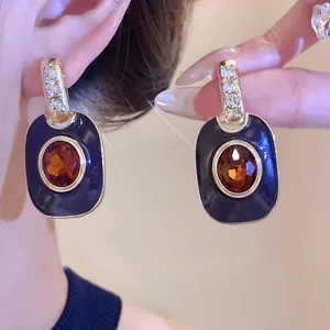 Detailansicht von Vintage-Ohrringen mit blauem Emaille und bernsteinfarbenem Stein