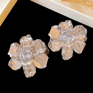 Detailed view of large silver-toned crumpled metal flower stud earrings for elegant women