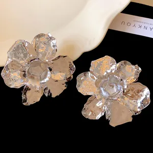 Close-up of large metallic silver wrinkled flower earrings with textured petals