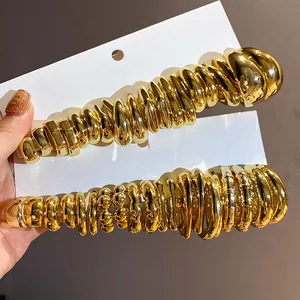 Detailed view of gold C-shaped earring sets with varied metallic textures and lustrous finish