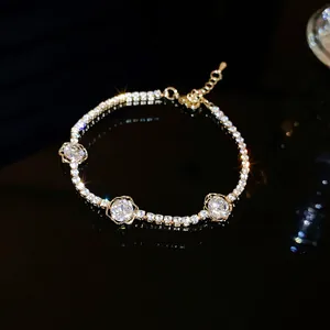 Gros plan détaillé d'un bracelet en or scintillant avec trois breloques roses en zircon