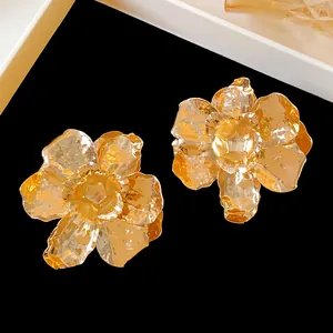 Detailed macro view of elegant gold metallic wrinkled flower stud earrings for women