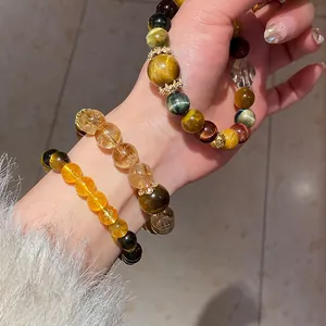Close-up detail of three elegant beaded bracelets with tiger eye and moonstone stones