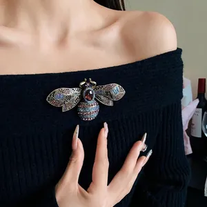 Vintage court style bee brooch with colorful rhinestones on black sweater